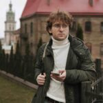 young man holding phone outdoors (1)